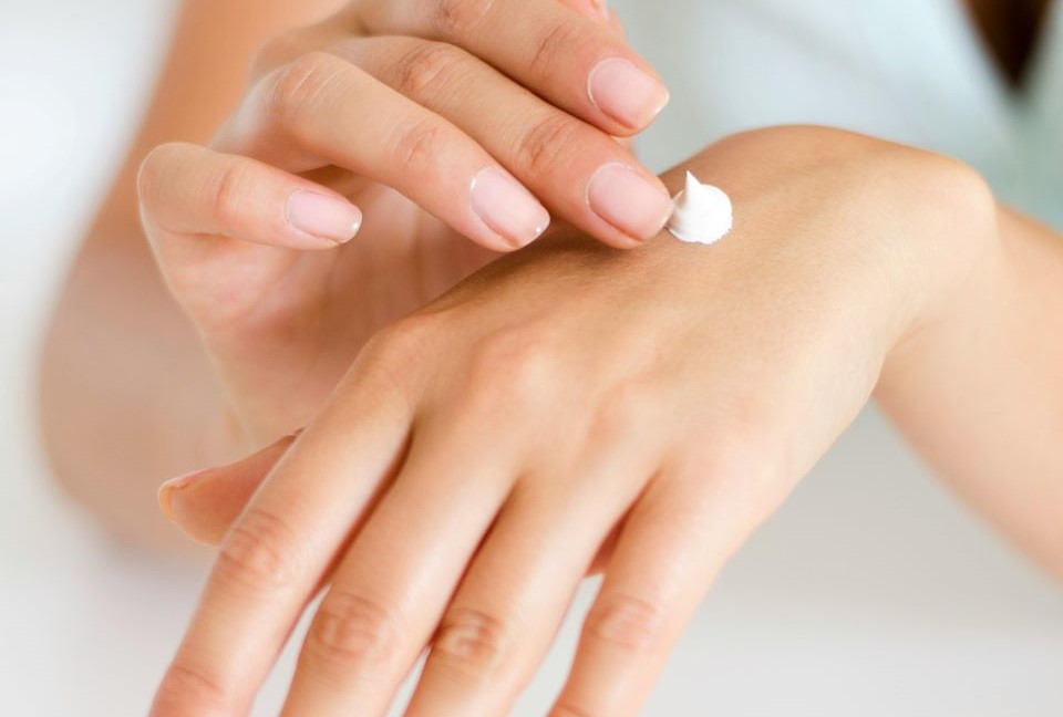 Woman Applying Lotion on Hand